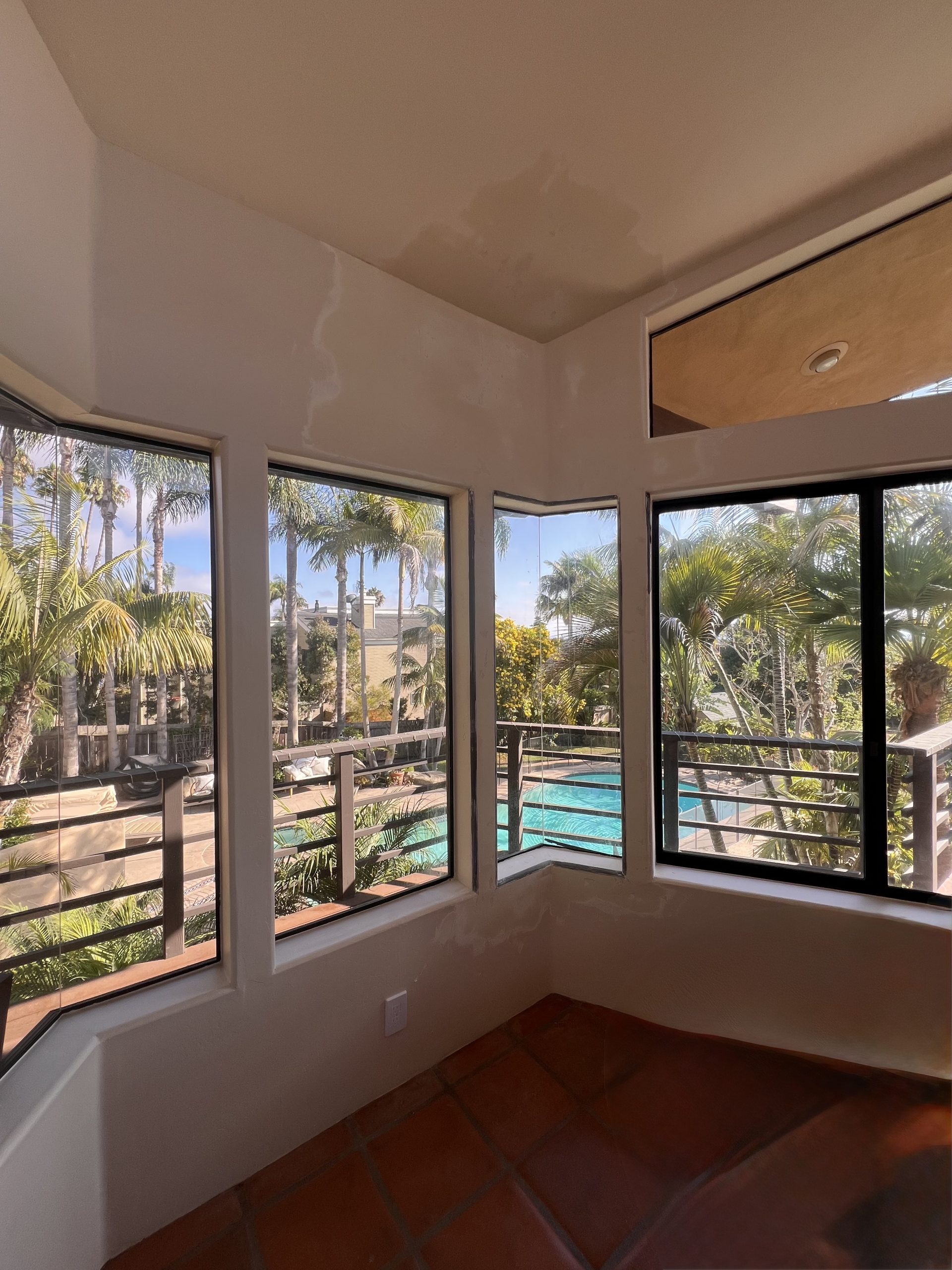 Skim coat patches blended into walls of a coastal home with pool and landscaping visible through the windows, La Jolla