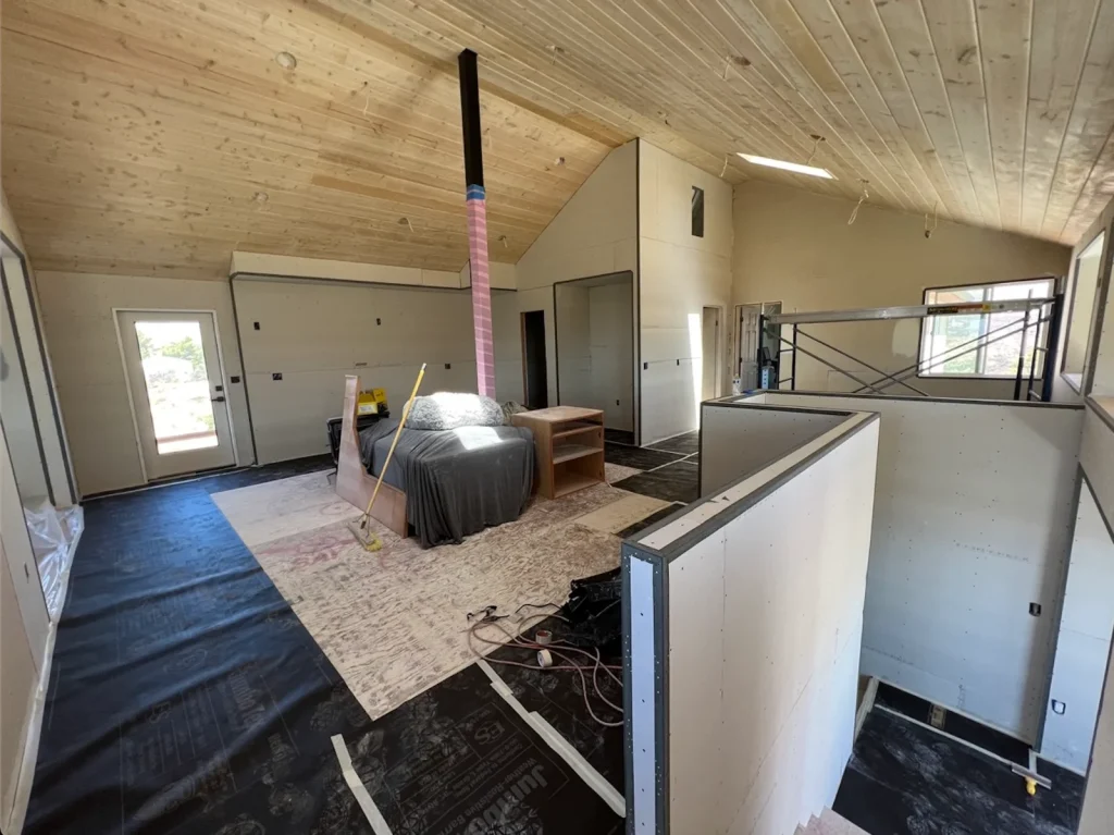 Finished ADU interior with smooth drywall walls and vaulted tongue-and-groove wood ceiling, San Diego